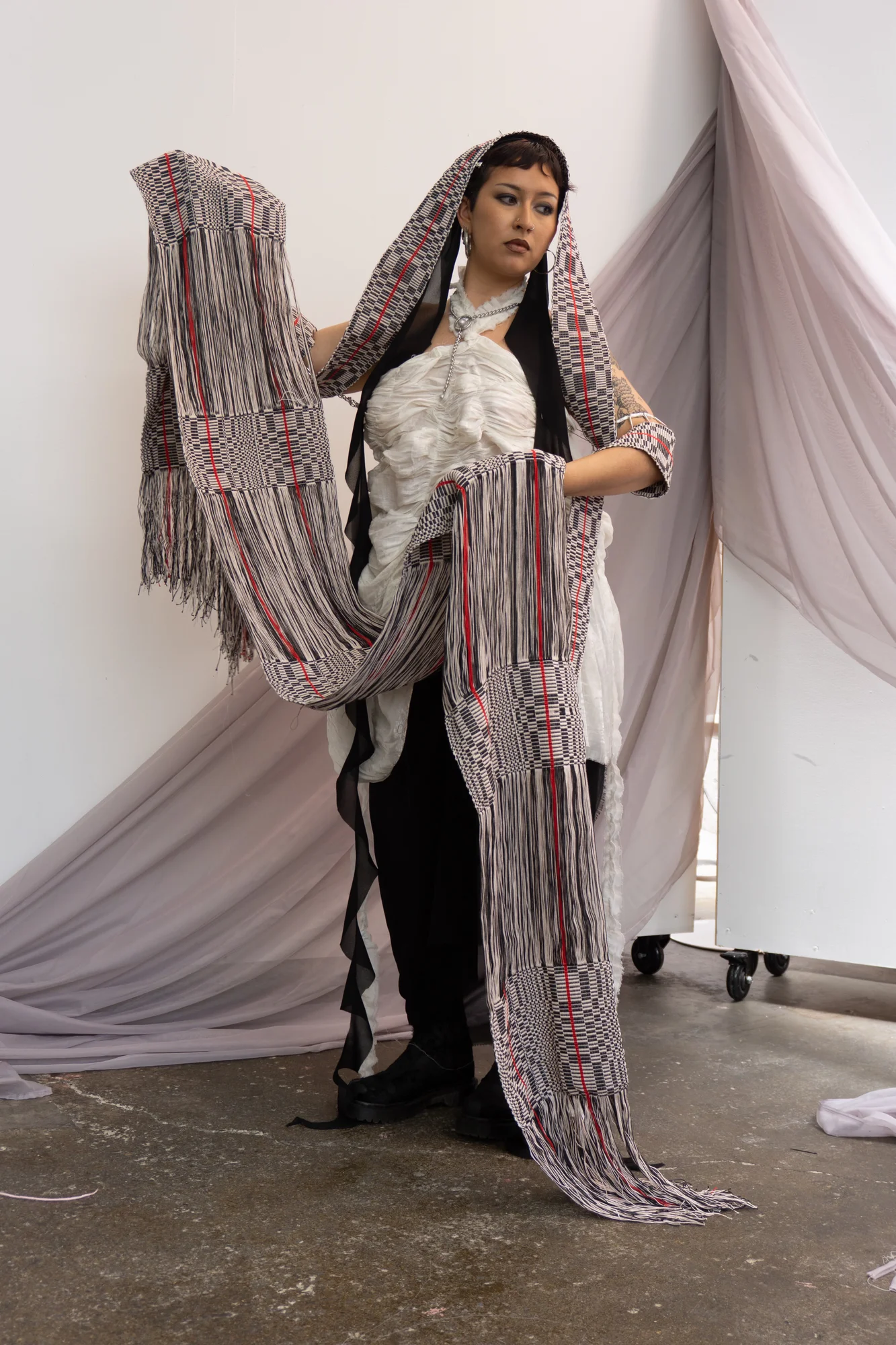 White lace look holding a long woven textile