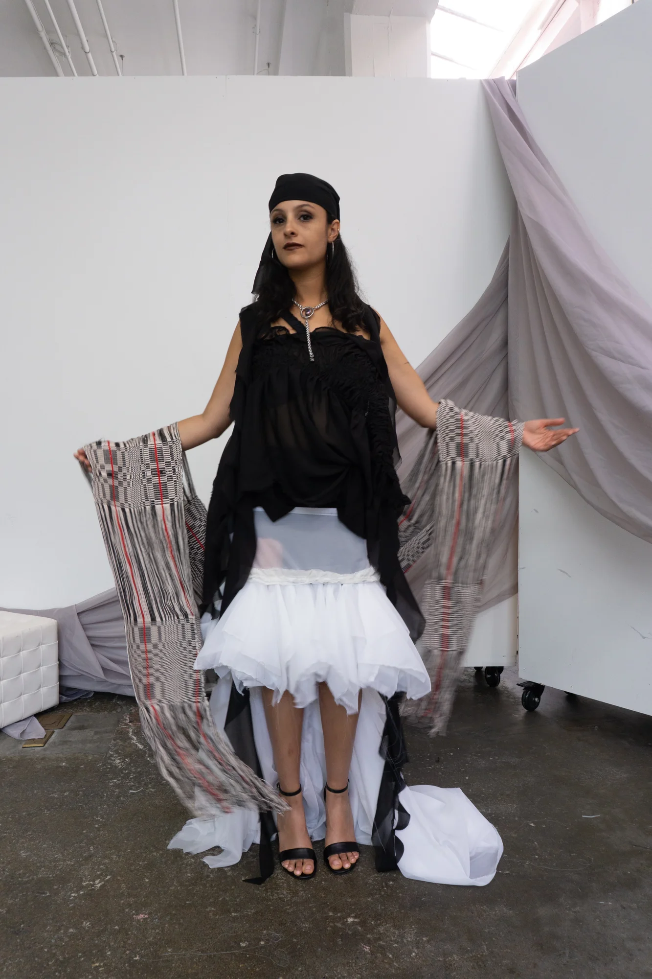 Black top and white layered skirt with draped woven sleeves