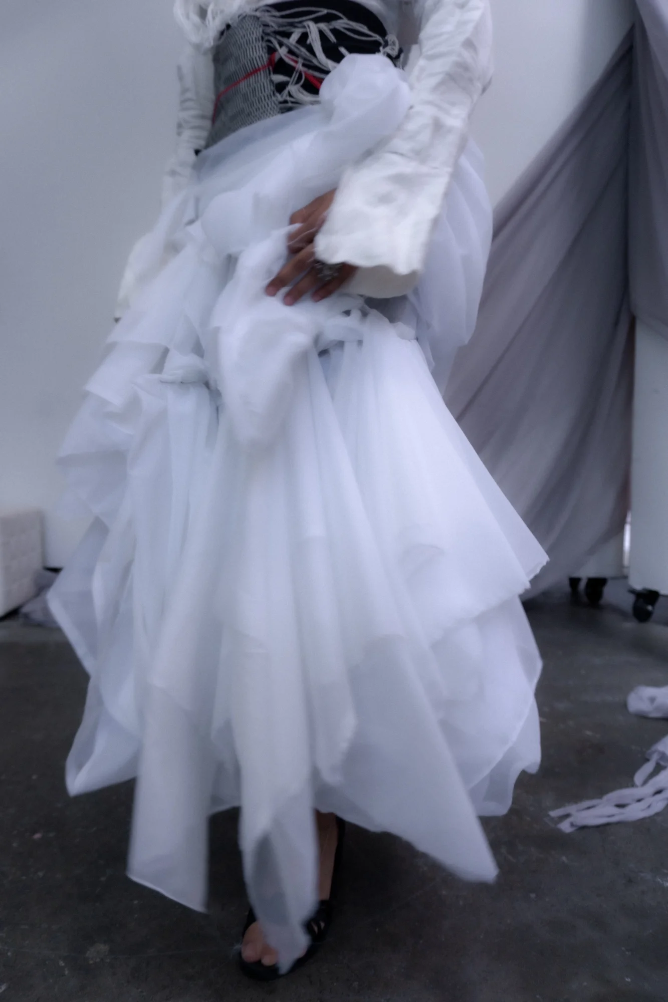 Detail of a layered white garment in motion