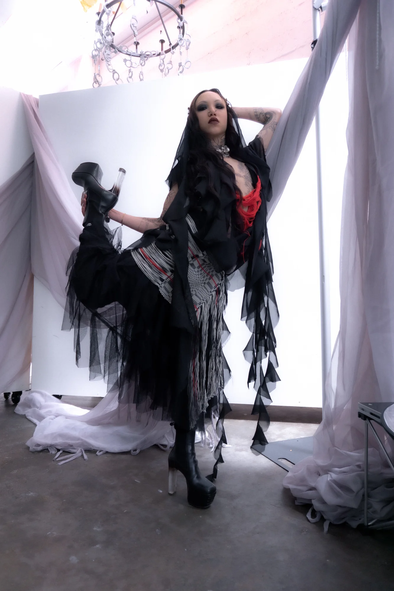 Black and red layered look in a draped studio